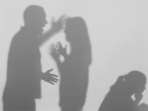 Silhouettes of quarreling parents and little child on white background. Domestic violence concept